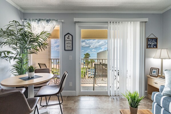 A living room with a dining area, a balcony with a view, and a sofa. - Water View Apartment Suite on the Beach! (Tampa)