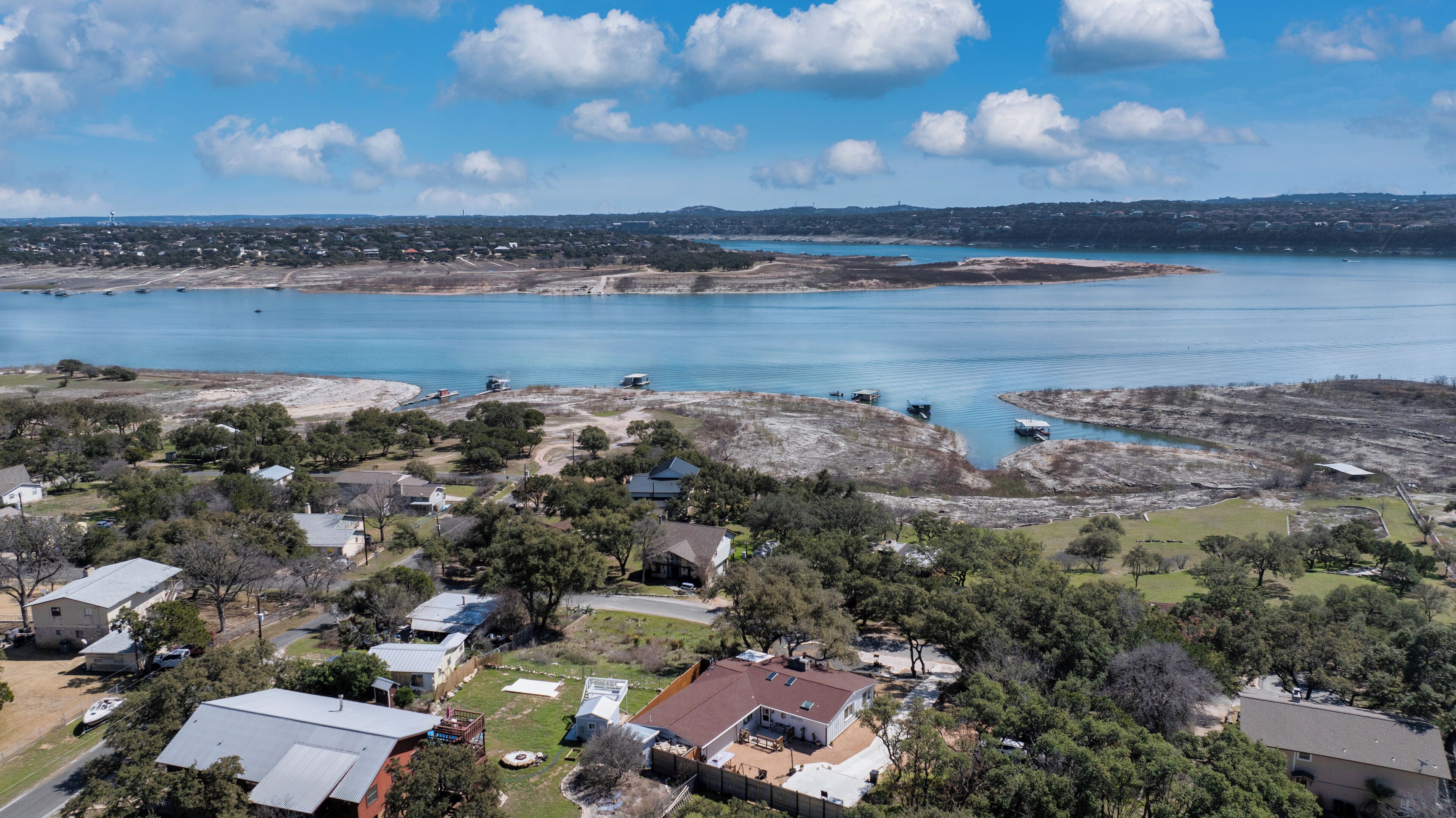 A residential area with houses, a large body of water, and a distant town.