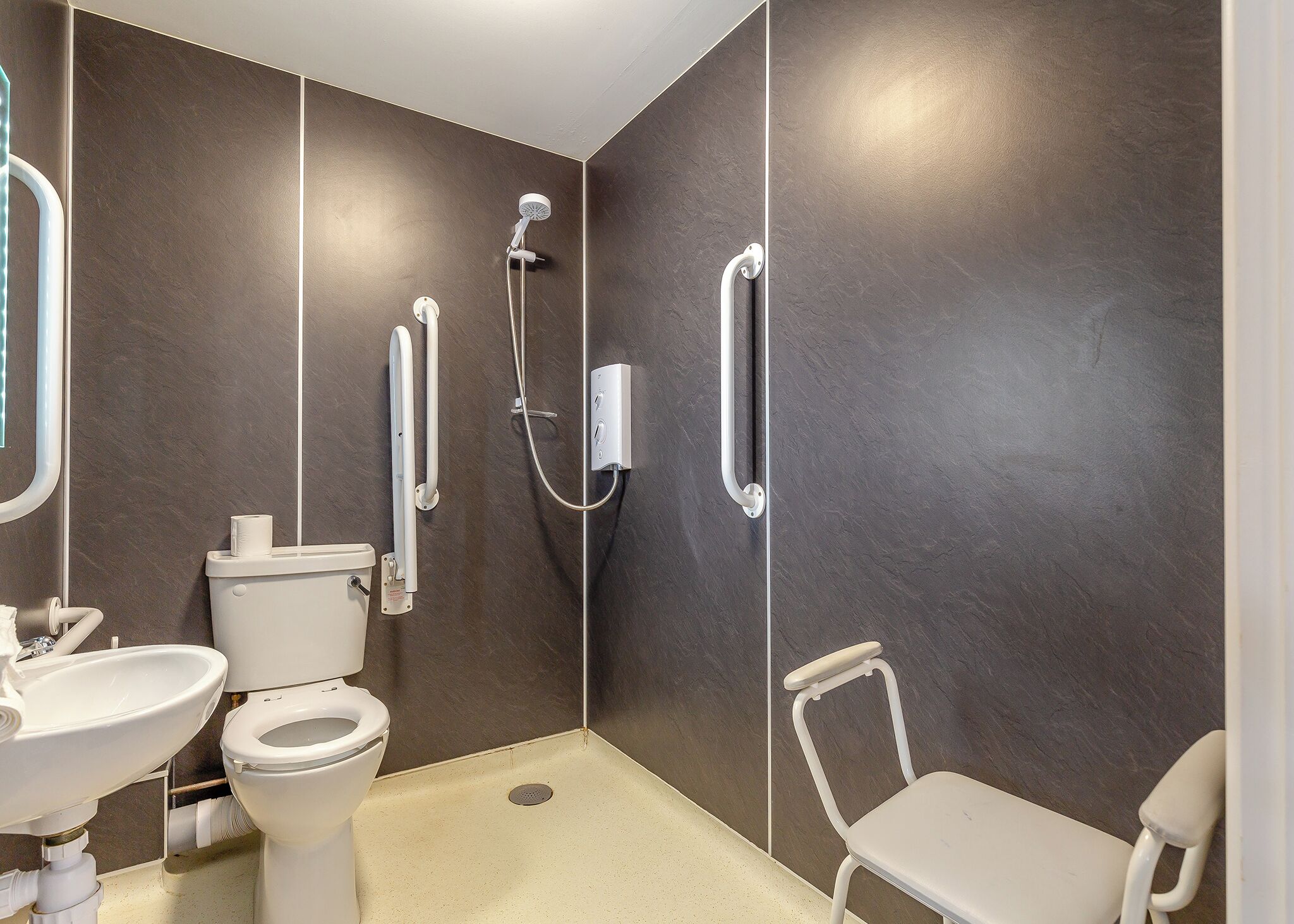 A modern bathroom with a toilet, sink, and shower.