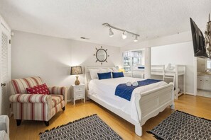 A bedroom with a bed, bedside tables, a chair, a mirror, and a television. - Sanderley | Canalfront | Fire Pit, Private Dock (Virginia Beach)