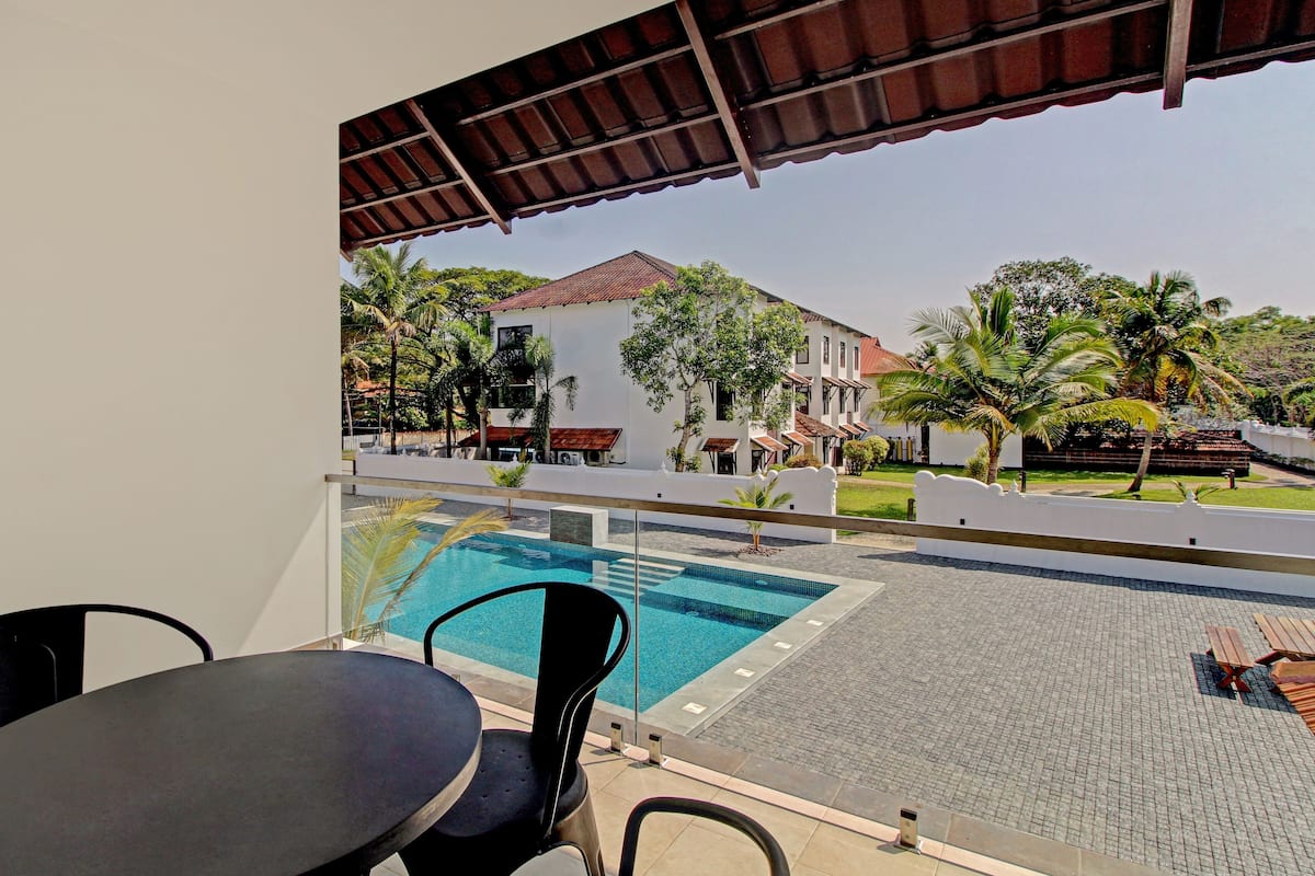 A balcony with a pool, chairs, and a table.