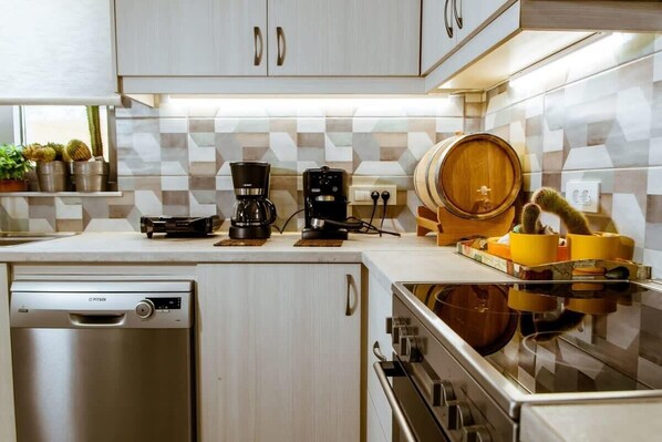 A modern kitchen with a dishwasher, coffee maker, and wooden barrel.
