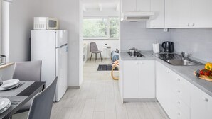 Une cuisine moderne avec des meubles blancs, un four à micro-ondes encastré et un évier.