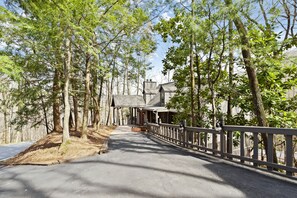Stroll along the tree-lined pathway to a charming, traditional building with a welcoming porch.