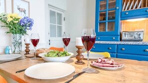 A dining table with plates, glasses, and a bowl of salad.