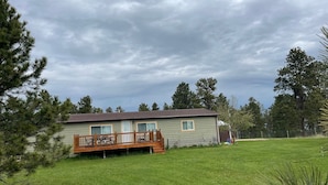 A single-story house with a fenced deck and a well-maintained lawn. - Peaceful and private with quick access to all the Black Hills has to offer! (Rapid City)