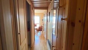 A wooden hallway with a sloped ceiling, wooden doors, and a wooden floor. - Appartement à 2 Minutes à Pied des Commerces et Télécabines Avec Superbe vue (Font-Romeu-Odeillo-Via)