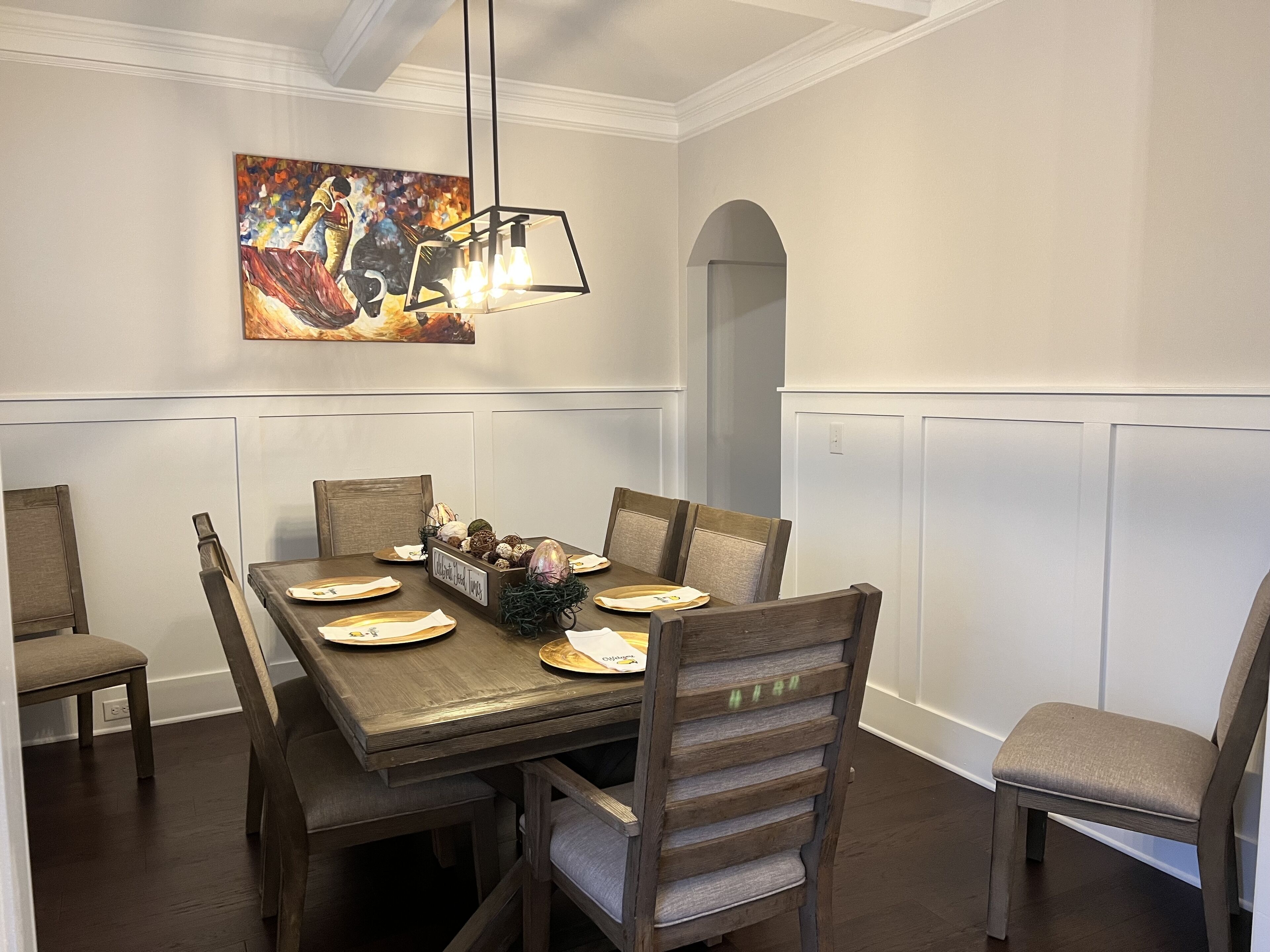 Comedor con una mesa de madera, seis sillas y un candelabro.