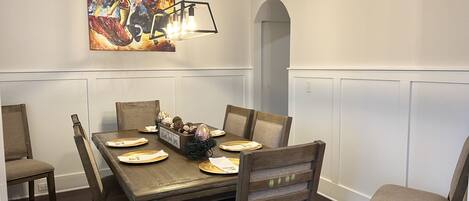Comedor con una mesa de madera, seis sillas y un candelabro.