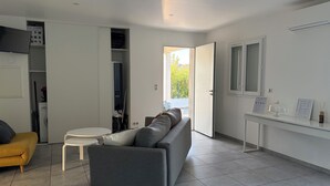 Un salon moderne avec un canapé gris, une petite table blanche et un fauteuil jaune.