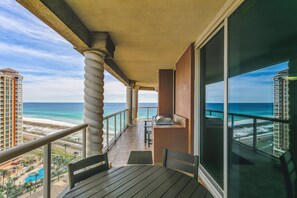Enjoy a panoramic view of the beach and ocean from this balcony, perfect for outdoor dining with a grill.