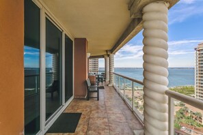 Enjoy the ocean view from this balcony with a seating area and table.