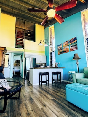A spacious living area with a kitchen island, a ceiling fan, and a dining area.