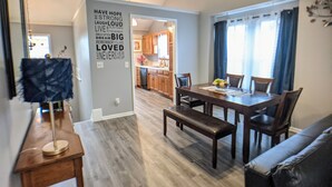 A modern kitchen with wooden cabinets and a dining area with a bench and table. - Beautiful, spacious, clean house for families #1 (Overland Park)