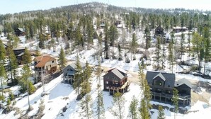 A cluster of cabins surrounded by a forest with snow on the ground. - Annie Creek Lodge – Hot tub, game loft, fireplaces & stunning views! (Lead)
