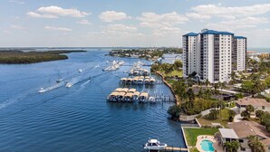 A marina with boats docked, a large hotel building, and a clear view of the water.