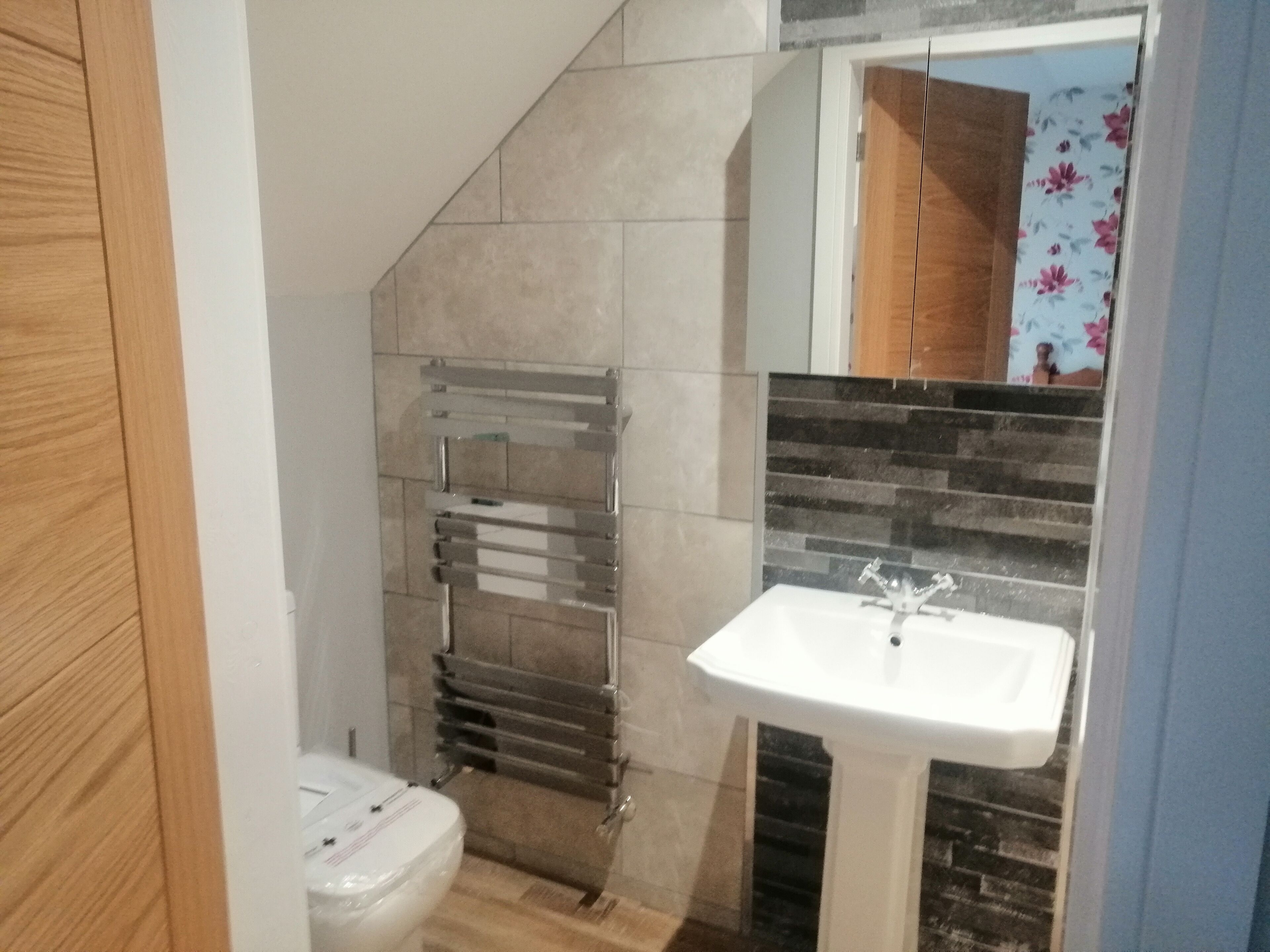 Un baño con inodoro, lavabo y toallero.