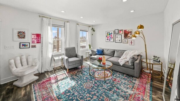 A modern living room with a grey sofa, a white armchair, and a patterned rug. - Tremont! 7 min to downtown Cle (Cleveland)