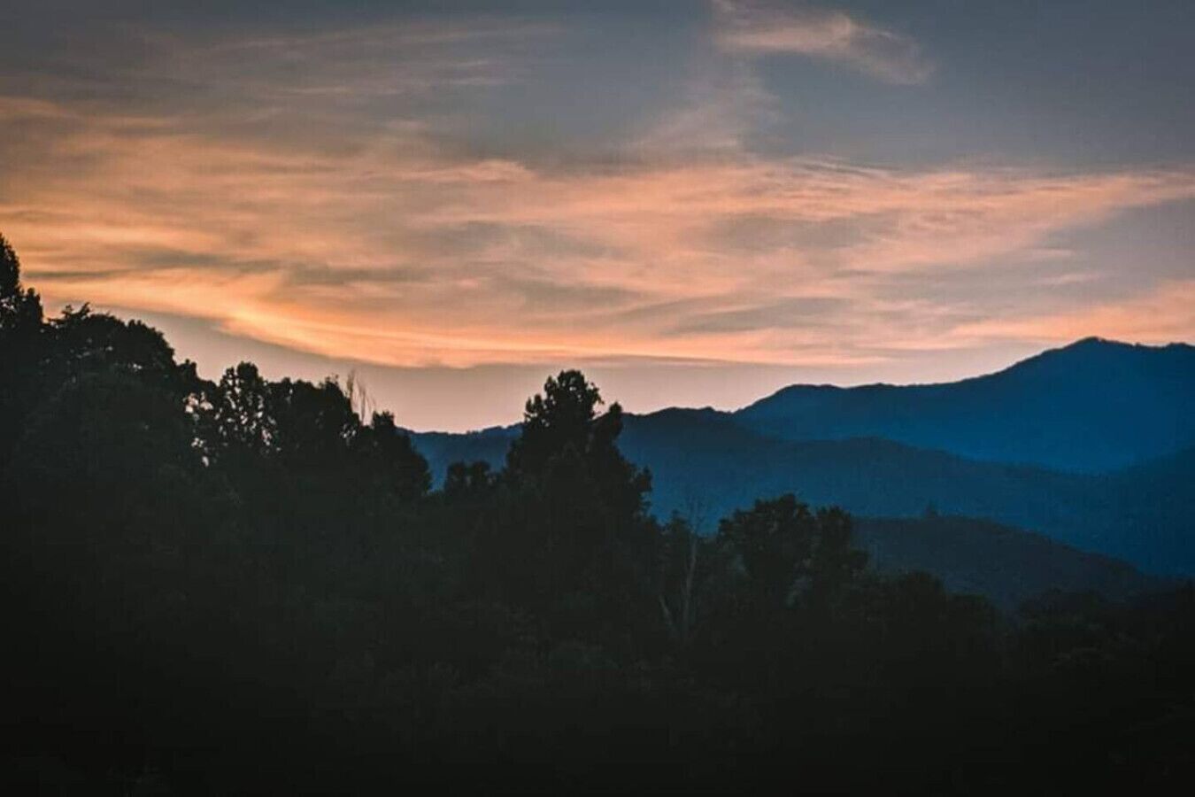 A mountainous landscape with a sunset.