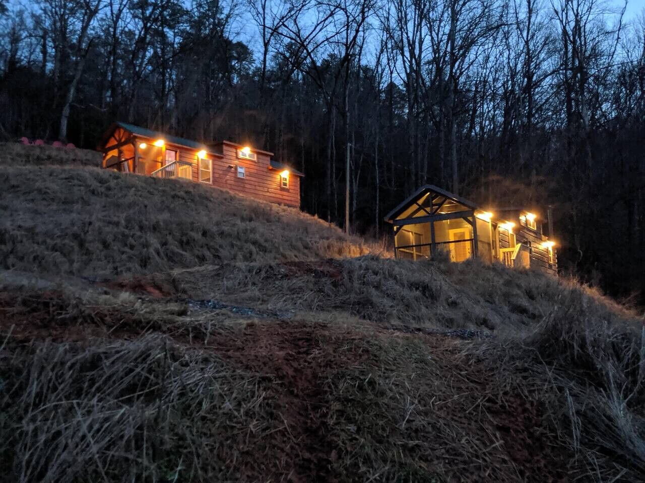 A cabin with a wooden exterior, a staircase, and multiple windows.
