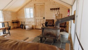 Un interior acogedor de madera con chimenea, un banco y una puerta.