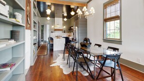 Une cuisine moderne dotée d’un îlot central, de planchers en bois et de luminaires suspendus.