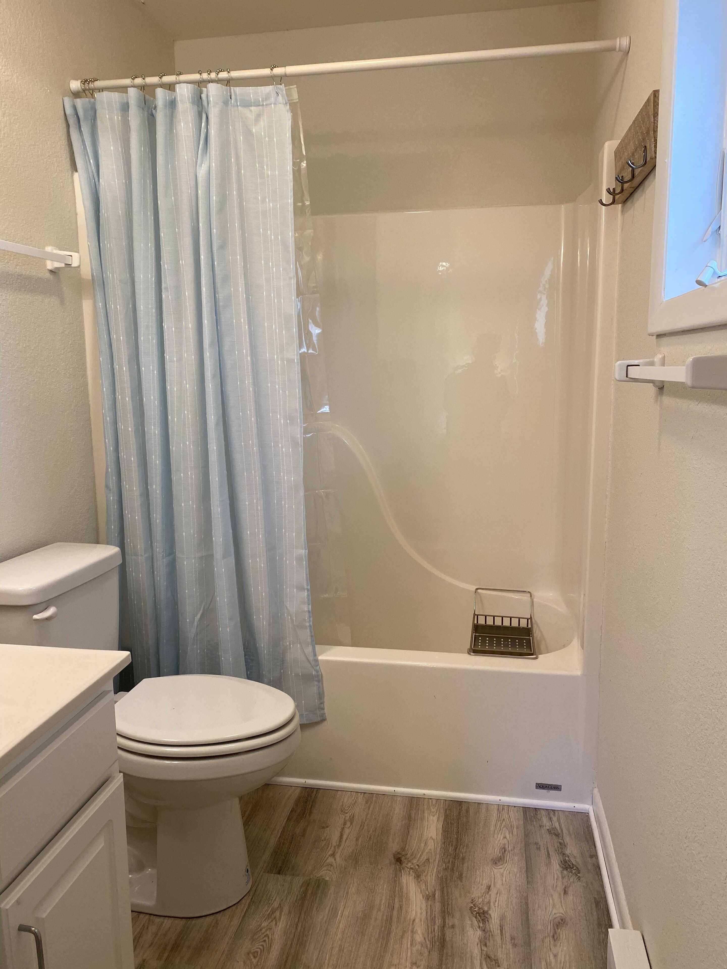 A bathroom with a toilet, a bathtub, and a shower curtain.
