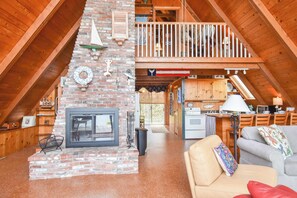 Ein geräumiges Loft mit hoher Decke, Kamin, Essbereich und gemütlicher Sitzecke.