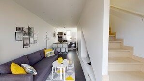 A modern apartment with a living room, kitchen, and staircase. - Paris House (Villejust)