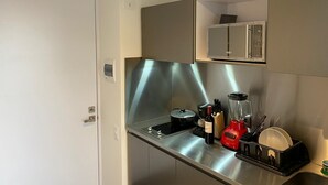 Una cucina moderna con elettrodomestici in acciaio inossidabile, forno integrato e una bottiglia di vino sul piano di lavoro.