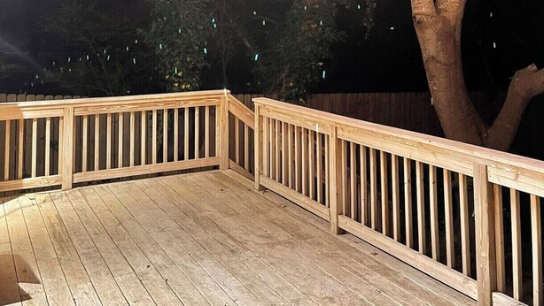 Eine Holzterrasse mit Lichterketten.