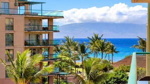 Ein mehrstöckiges Hotel mit Balkonen mit Blick auf Strand und Meer.