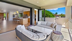 A modern open-plan living area with a dining space, kitchen, and a balcony with a view.