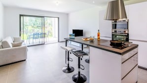 A modern kitchen with a central island, bar stools, and a large window. - Domaine d'Arca by Interhome (Porto Vecchio)