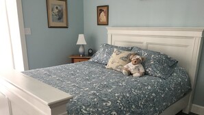 A bedroom with a bed, a nightstand, a lamp, and a teddy bear. - Country Blue is close to forest trails and beach (Qualicum Beach)