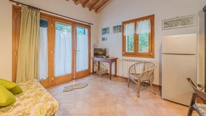 Une chambre confortable avec un lit, une télévision, un coin repas avec des chaises et un réfrigérateur.