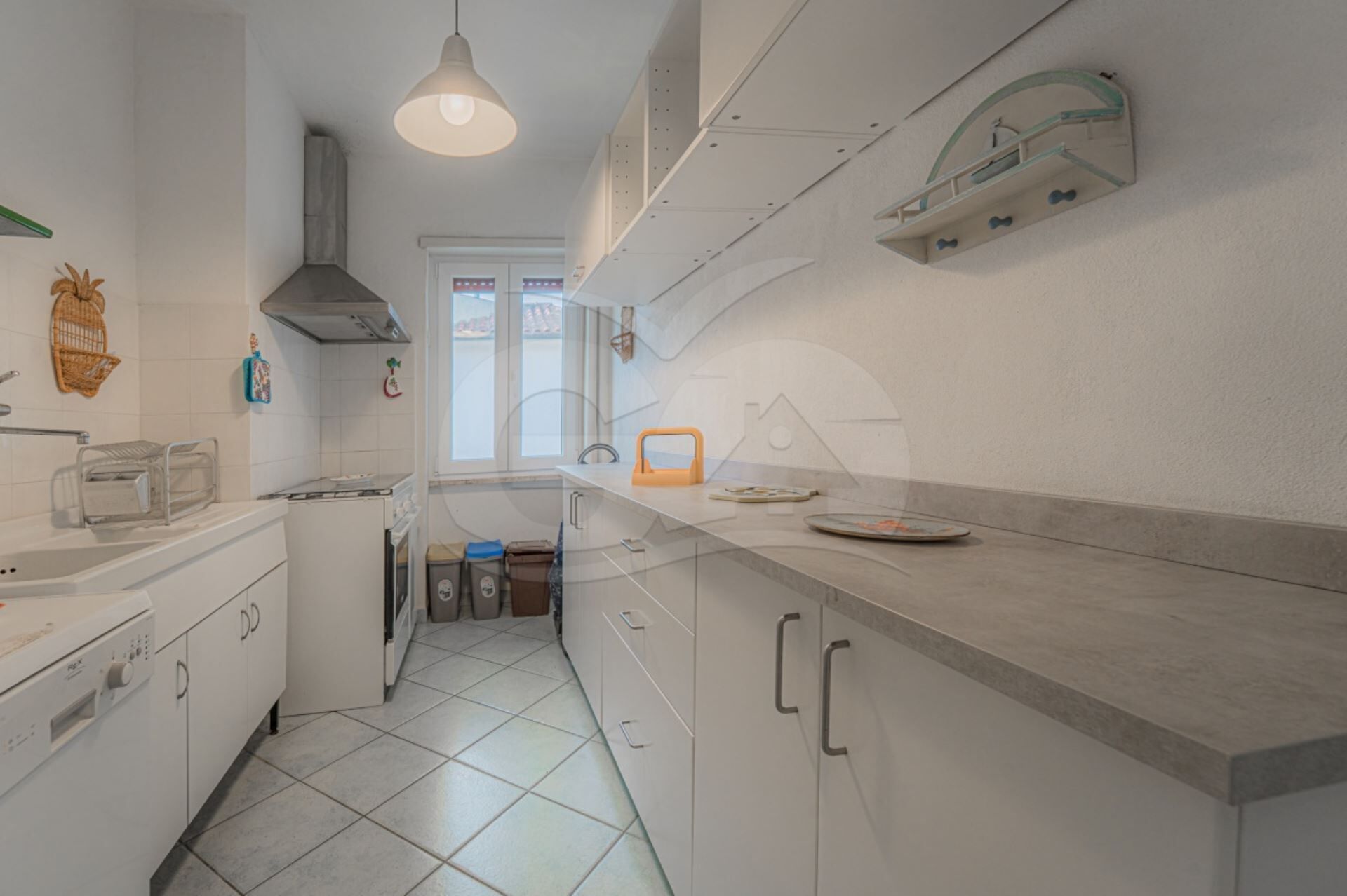 A modern kitchen with white cabinets, a stainless steel range, and a window providing natural light.