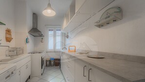 A modern kitchen with white cabinets, a stainless steel range, and a window providing natural light.