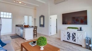 A modern living room with a wooden coffee table, a white cabinet, and a large flat-screen TV. - Ocean Front * Panoramic Water View Deck * A/C (San Diego)