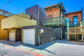 Un immeuble à plusieurs étages doté d’un garage, d’un balcon et d’une terrasse en bois.