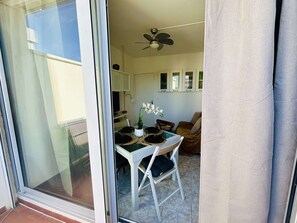 A dining area with a table, chairs, and a ceiling fan.