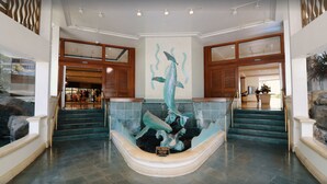 A lobby with a central fountain, a staircase, and a reception area. - Oceanfront Waikiki/Ilikai Condo w/Stunning View and Parking Included! (honolulu)