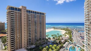 A high-rise hotel with multiple balconies overlooking a beach and a pool area. - Oceanfront Waikiki/Ilikai Condo w/Stunning View and Parking Included! (honolulu)