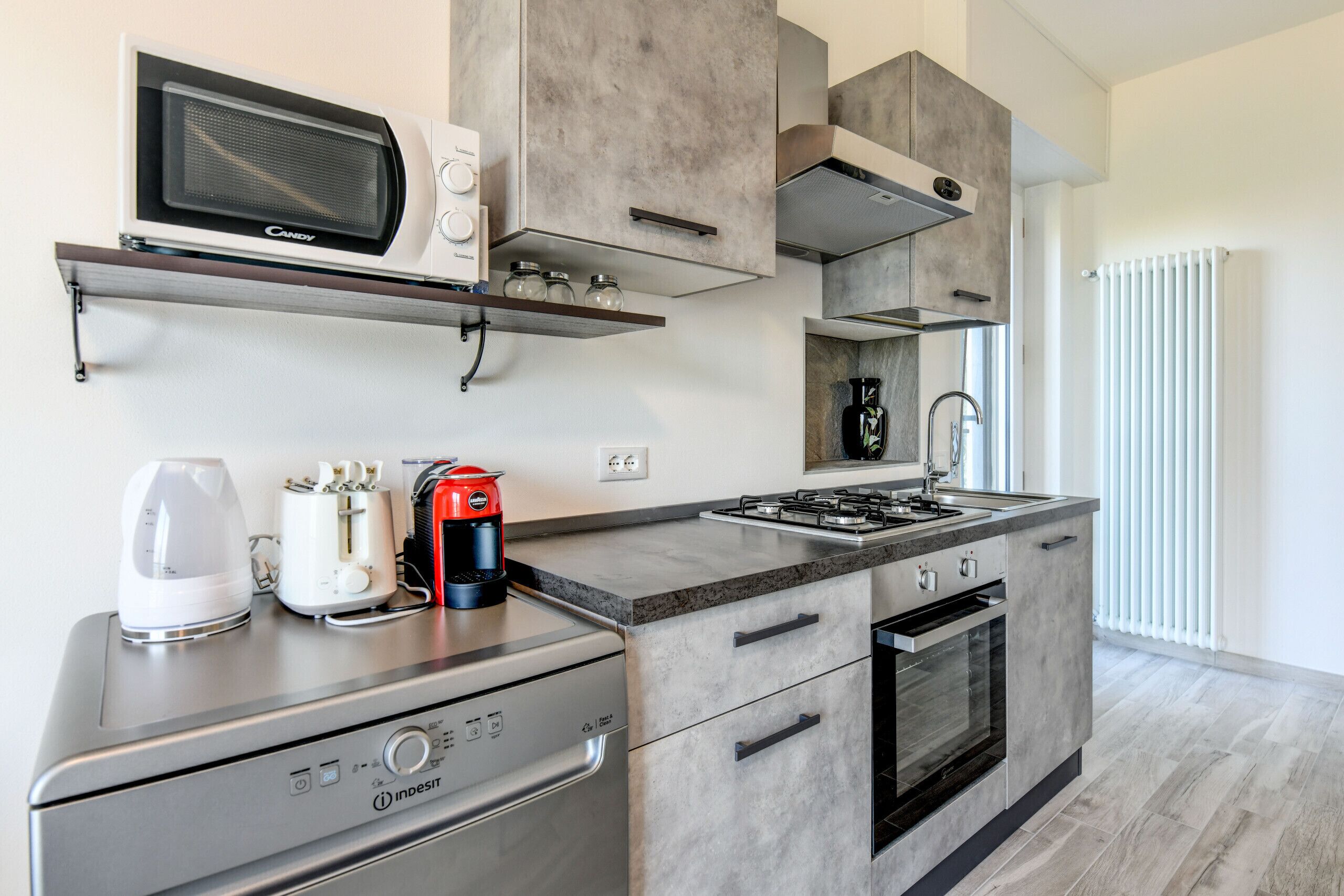 A modern kitchen with a built-in microwave, coffee maker, and gas stove.