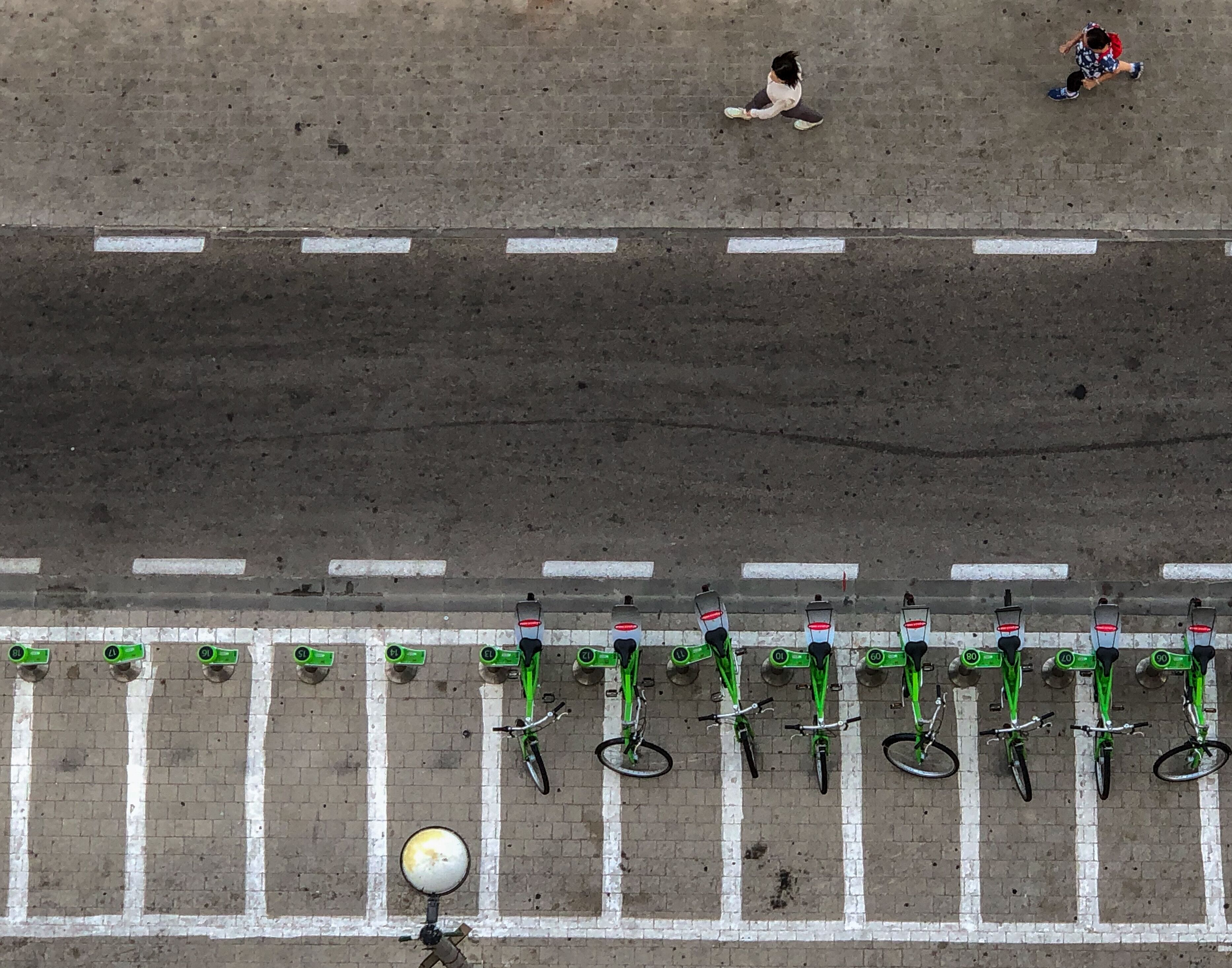 A parking area with bicycles and a pedestrian walkway.