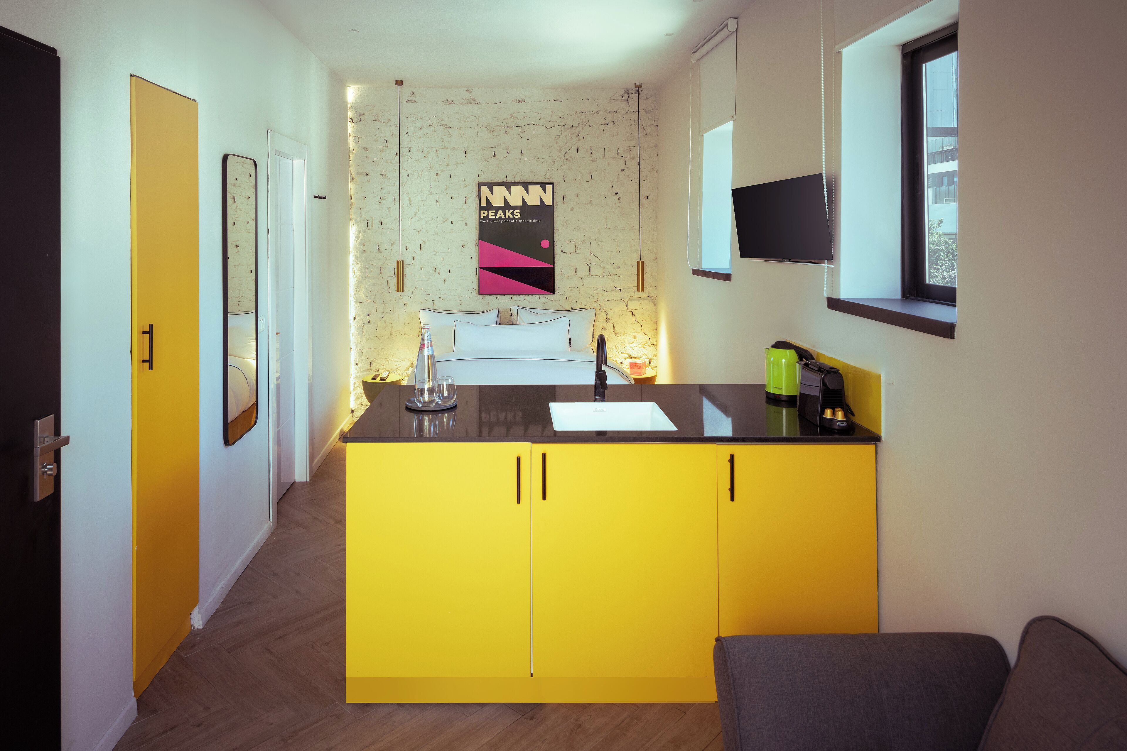 A compact kitchen with a yellow countertop, a built-in sink, and a window above the sink.