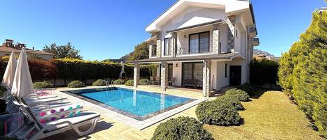 Una piscina al aire libre, tumbonas