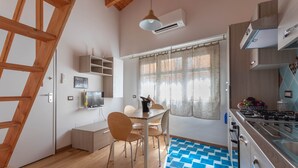 A modern kitchen with wooden cabinets, a gas stove, and a dining area with a table and chairs.
