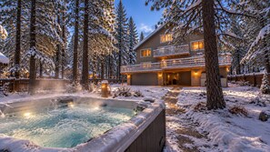 A spa area with a hot tub surrounded by snow-covered trees and a building with a balcony. - Ski Lodge 2 Min to Slopes · Sleeps 16 · Game Room (Big Bear)