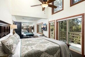 A spacious bedroom with a large bed, a ceiling fan, and a view of the outdoors through a sliding glass door. - Ski Lodge 2 Min to Slopes · Sleeps 16 · Game Room (Big Bear)